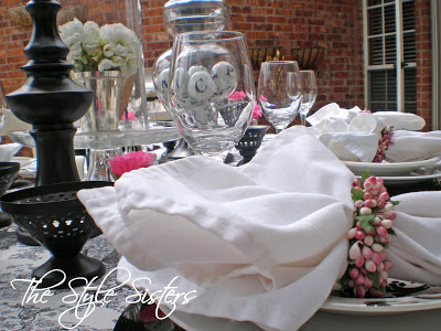 Black and white tablescape white napkins with pink berry wreath napkin rings