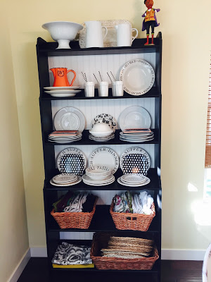 Fall decorated hutch with black and white dishes and pops of orange