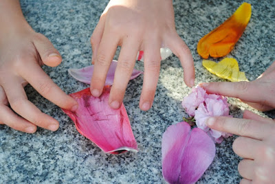children's hands and flower petals