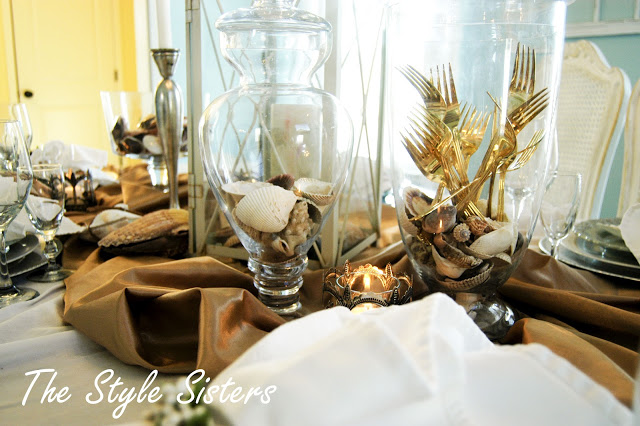 Beachy Tablescape using apothecary jars filled with sea shells and gold silverware