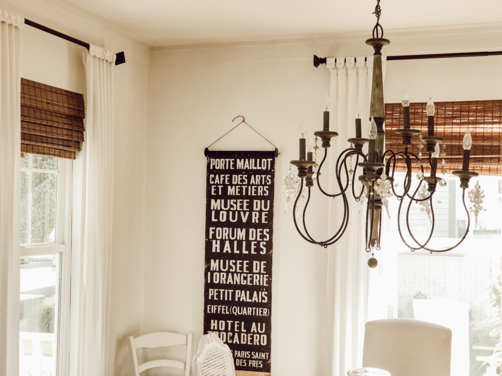 bamboo shades in dining room with chandelier