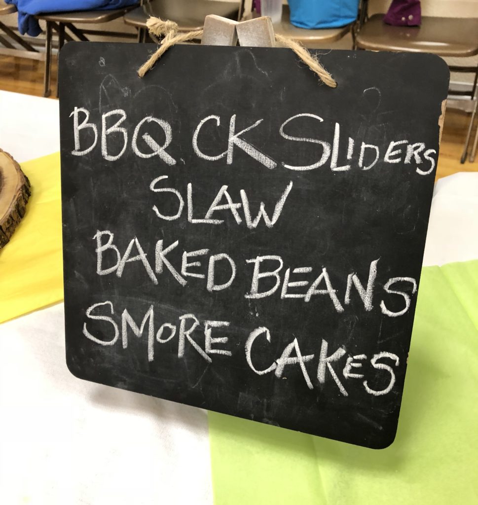 camp food chalk board menu BBQ chicken sliders, coleslaw, baked beans and s'more cupcakes