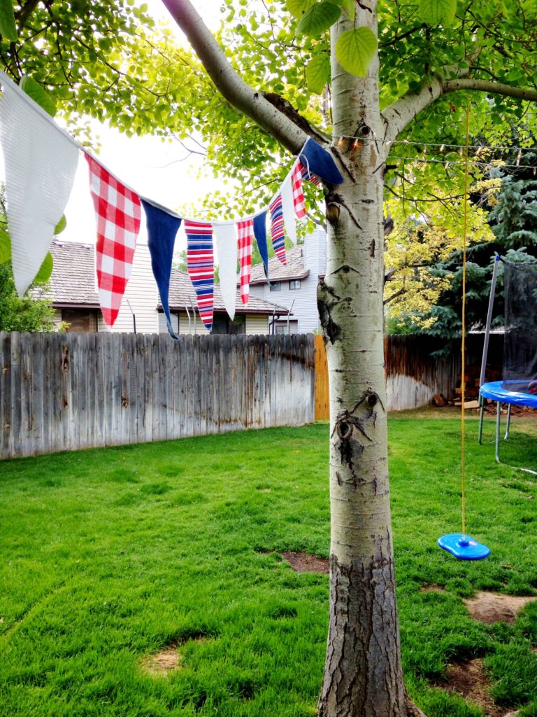 4th of July red white and blue fabric banner hanging from trees