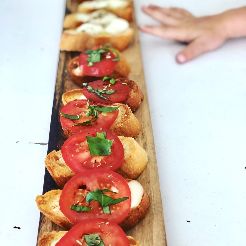Easy tomato bruschetta served on a long wooden board. 