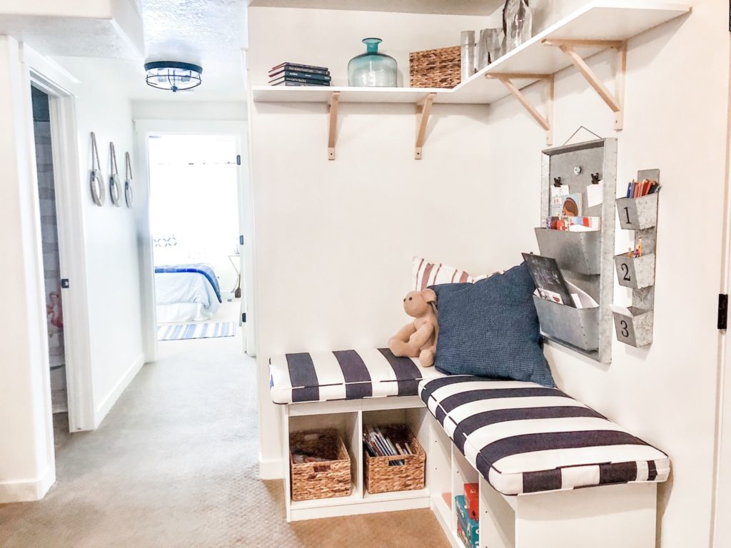 Easy reading nook created in basement makeover. Navy and white striped cushions from Pottery Barn.