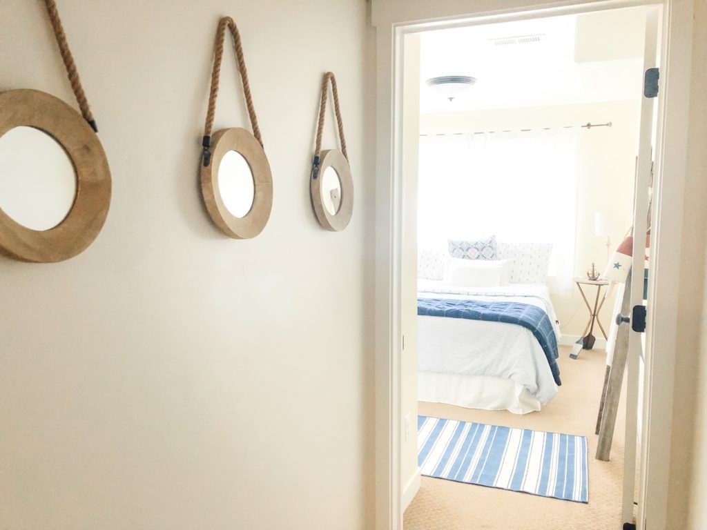 Port hole mirrors lining the hallway in basement makeover