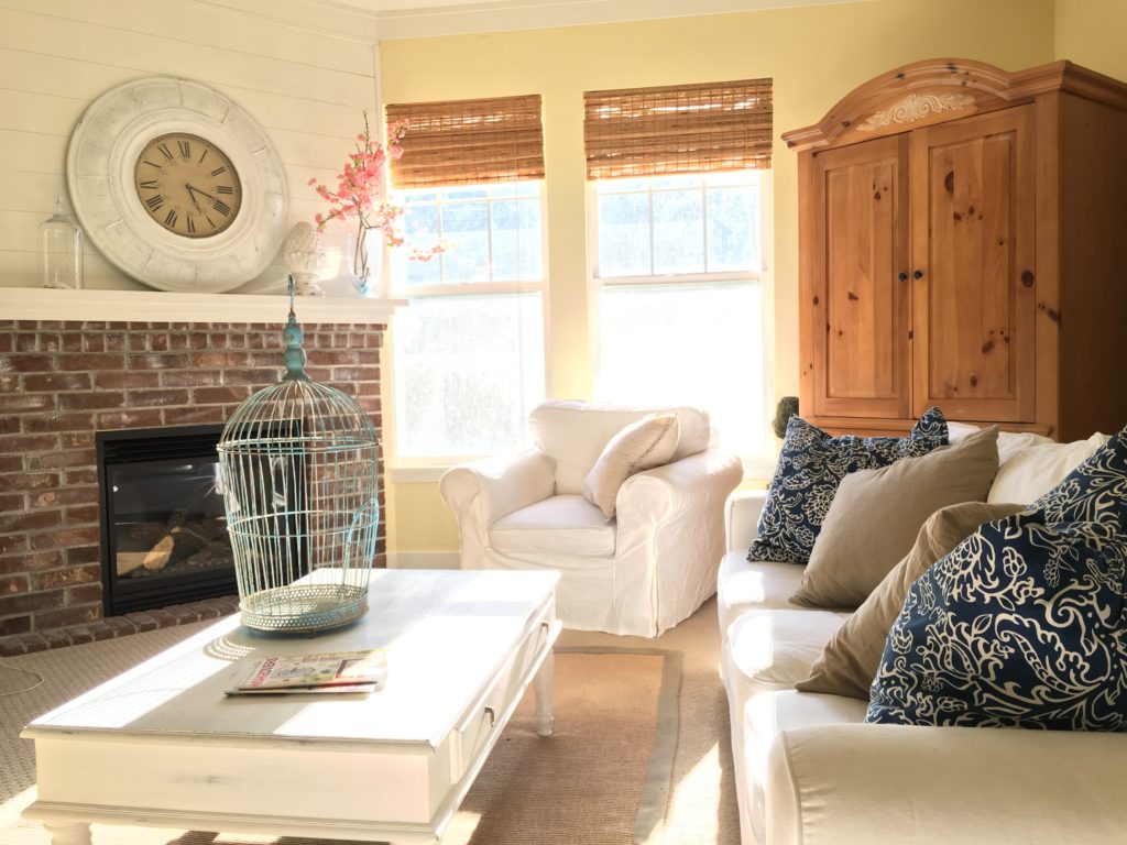 Brick fireplace with armoire white sofas