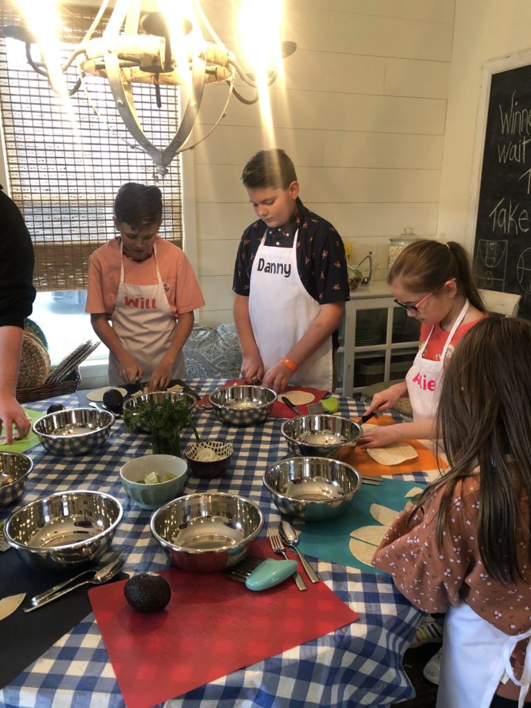 Boys and girls learning how to cook tacos 
