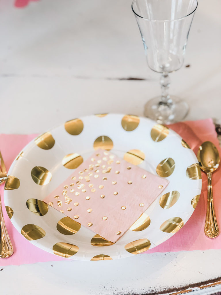 gold and white polka dot plate with pink napkins
