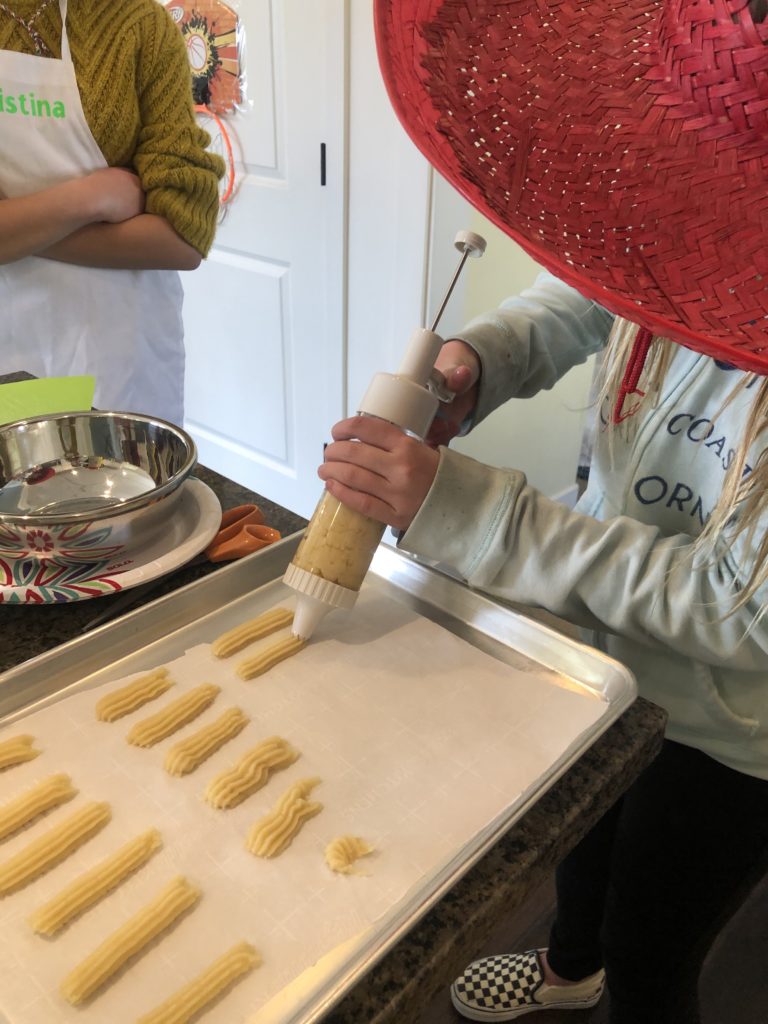 kids pressing out the churro dough 