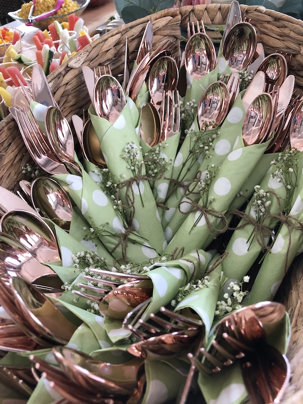 copper silverware wrapped in napkins and tied with baby's breath