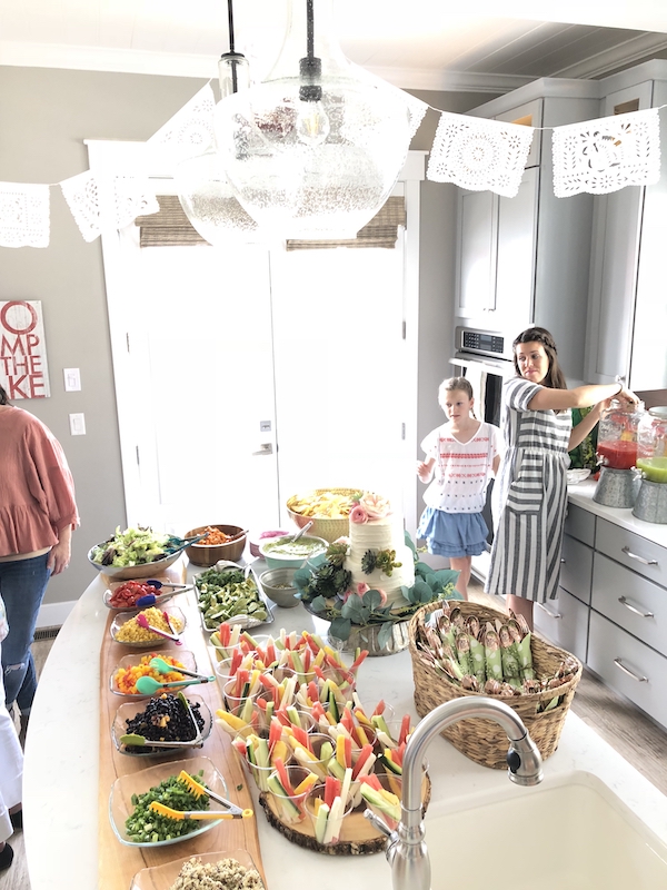 Taco salad bar. Food is set up on kitchen island. Taco bar baby shower