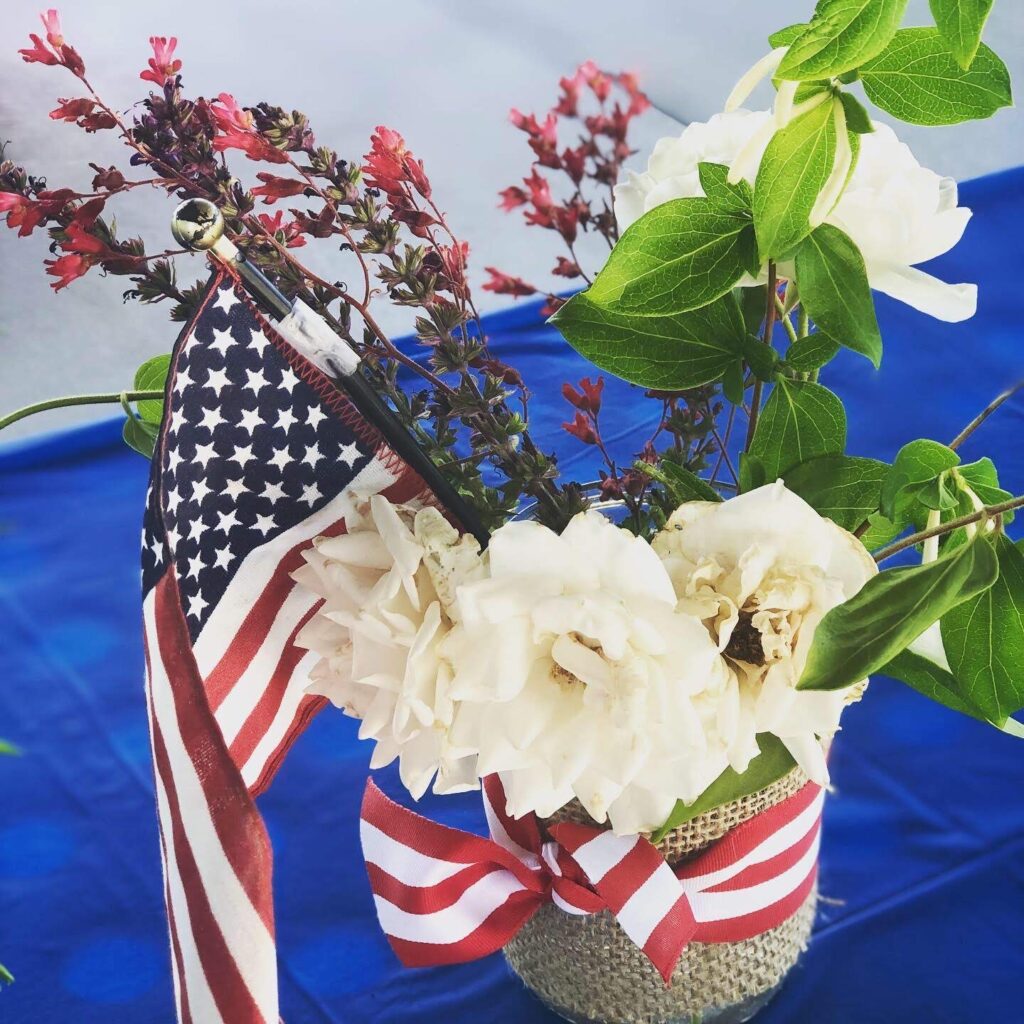 Red white and blue mason jar vases with white roses.