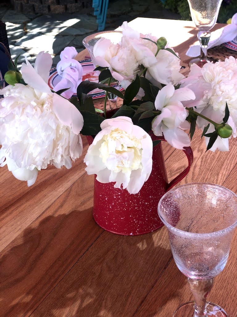 red coffe pot holding peonies 