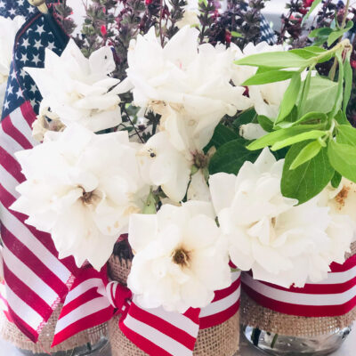 red white and blue mason jar vase with red and white striped ribbon