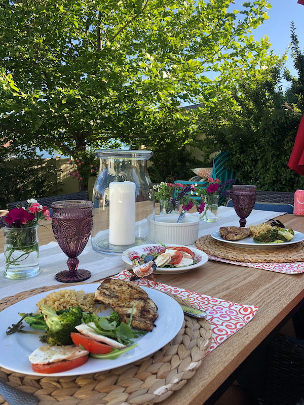 Dinner for two in backyard using an Ikea BEGÄRLIG Vase, clear glass, 11 ½ " with candle in it for centerpiece.