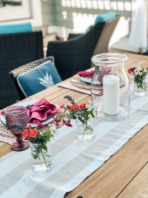 outdoor dining for two with Mini vases down the table filled with backyard flowers