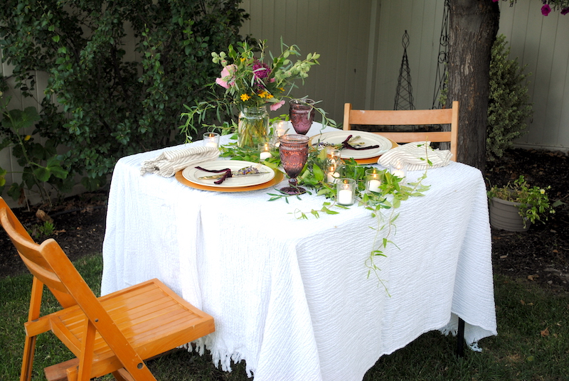 Romantic outdoor dinner at home under a tree. Using a card table with lumber under one side to level the table.