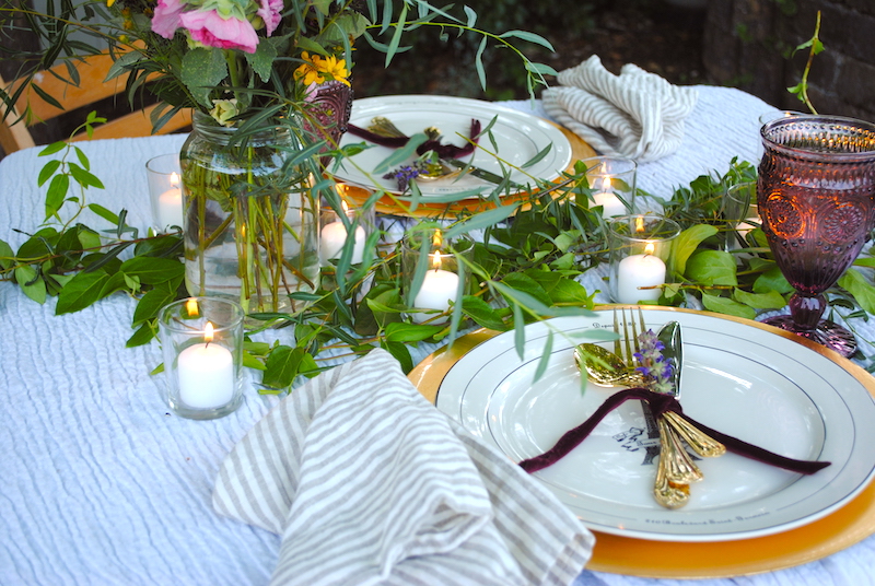Cut greens down the center of the table with mini candles, purple goblets