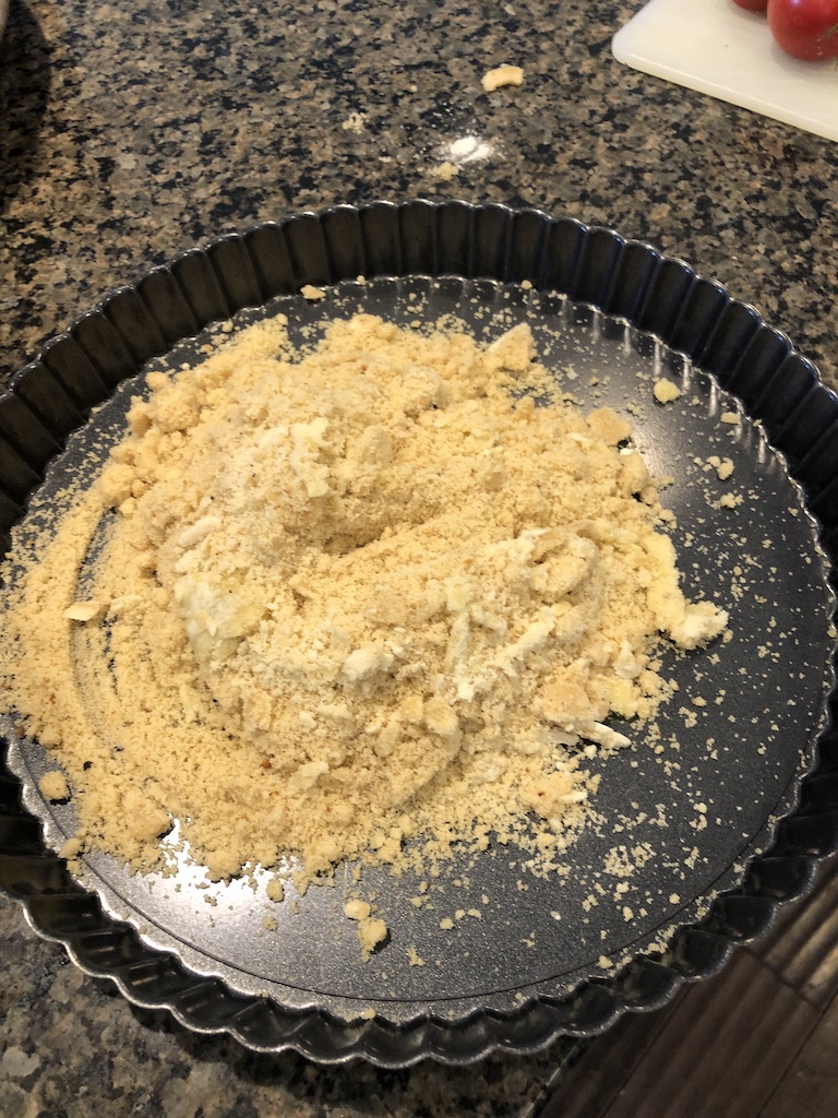 Tart pan with crust ingredients ready to be pressed into tart pan.