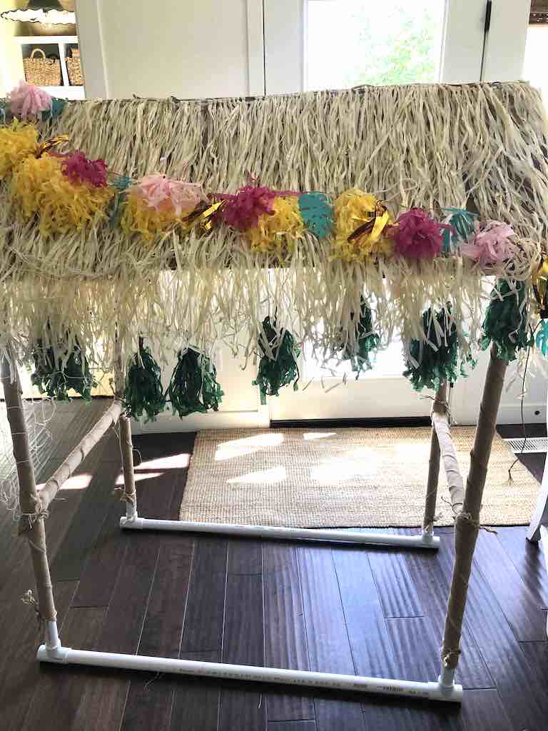DIY tiki Bar made with PVC pipes, Grass skirts, paper garlands burlap wrapped legs