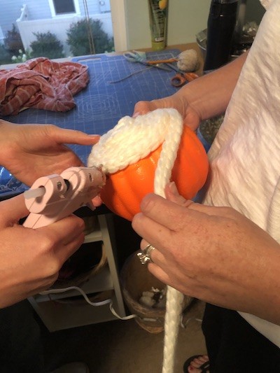 attaching yarn with hot glue on pumpkin
