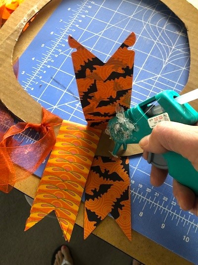 Hot glue Halloween paper strips to cardboard