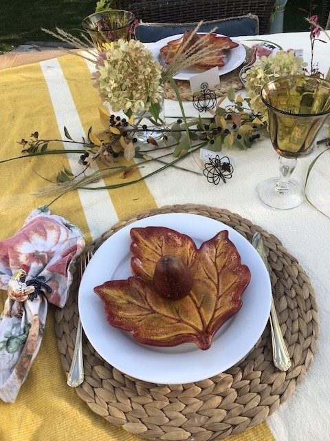woven placemats with white dinner plates, orange shaped leaf salad plate and gold silverware