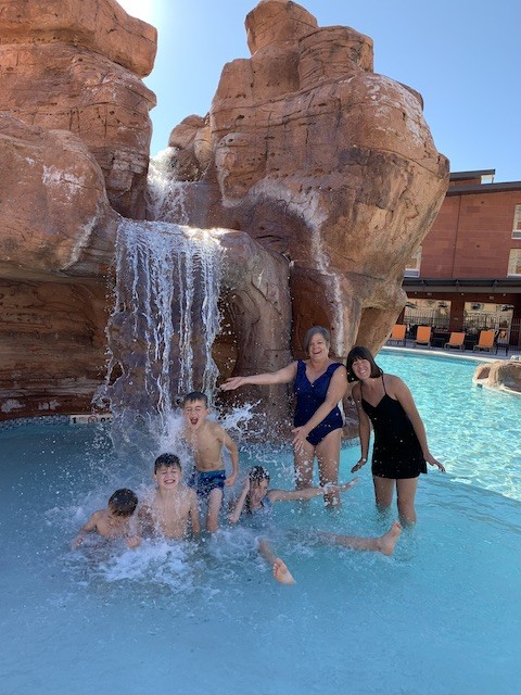 Family in waterfall at pool