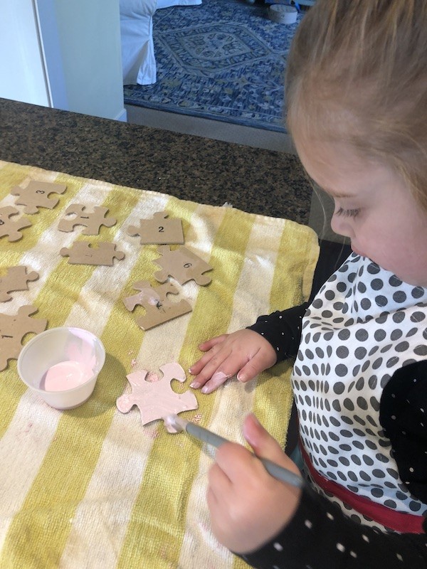 Painting the puzzle pieces pink with children