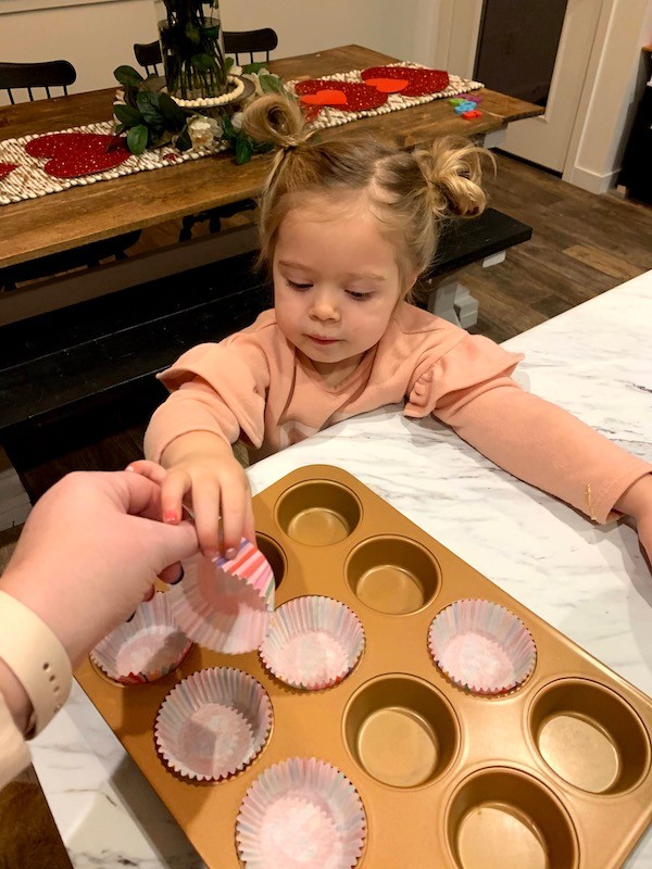 placing cupcake liners in cupcake pan