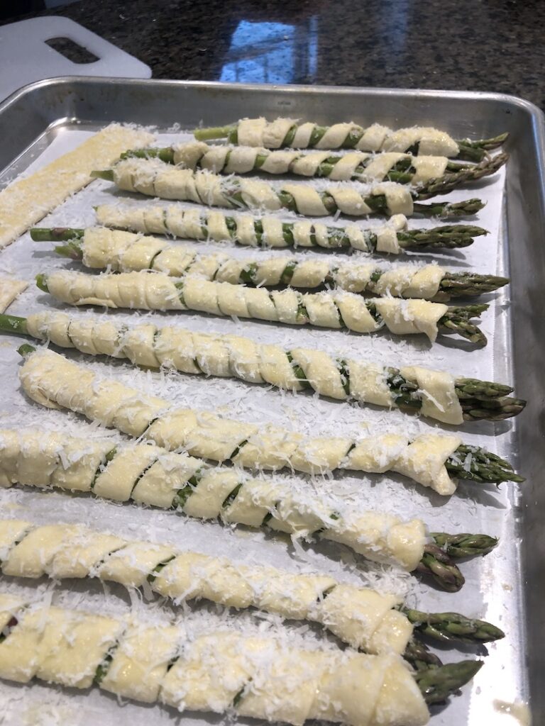 wrapped asparagus spears on cookie sheet