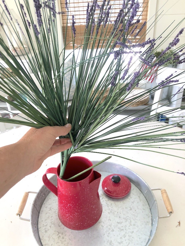 adding faux flowers to coffee pot