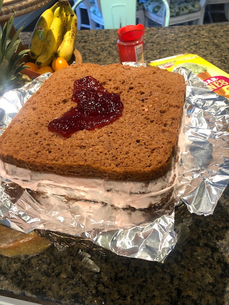 adding jam between layers of castle cake
