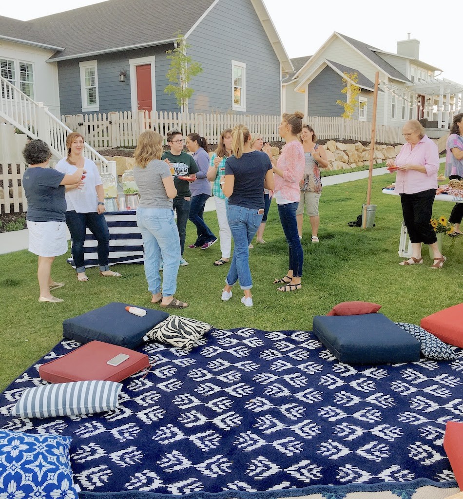 outdoor pillows and rugs on grass by lake
