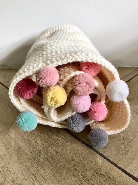 blanket with colorful pom poms