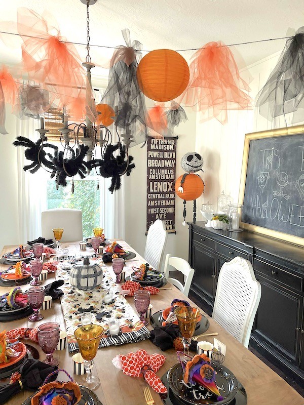 Orange and black Halloween tablescape with crepe paper and paper lanterns- Karins Kottage