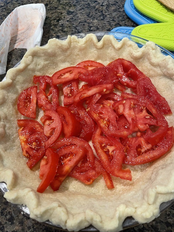 sliced tomatoes in homemade  pie crust