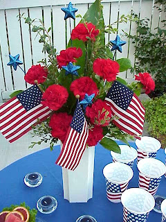 red carnations in white vase for Memorial day.