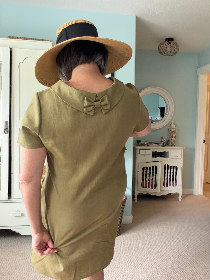 Back view of olive green LeMuse linen dress showing the small bow detail at the neckline