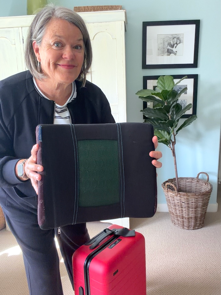 ravel back support cushion packed with carry-on luggage for a long flight to Italy.