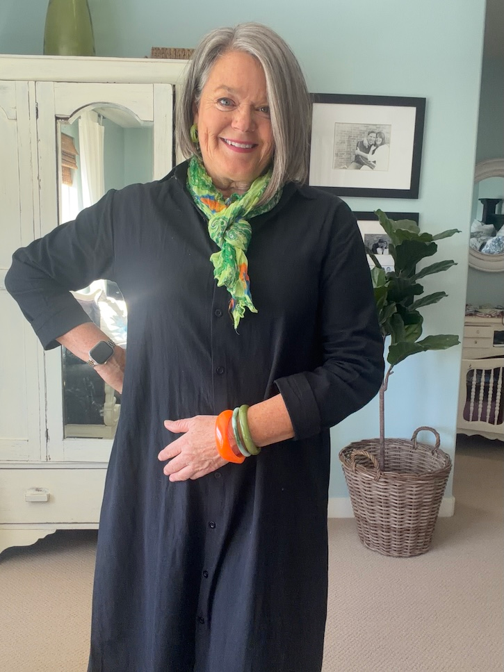 Black shirt dress styled with a bright green and orange scarf