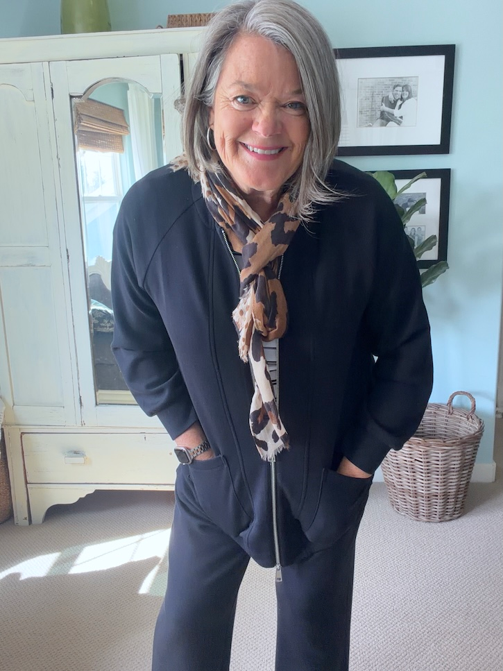Black travel outfit styled with an animal-print scarf for an easy day-to-evening look in Italy.